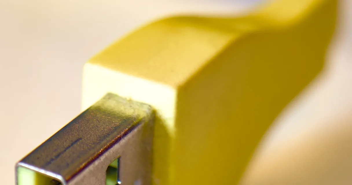 Conector USB amarelo em close, ilustrando como limpar dados do sistema no iPhone